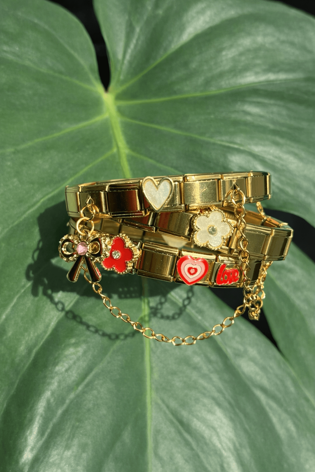 Gouden charm armbanden op een groen blad