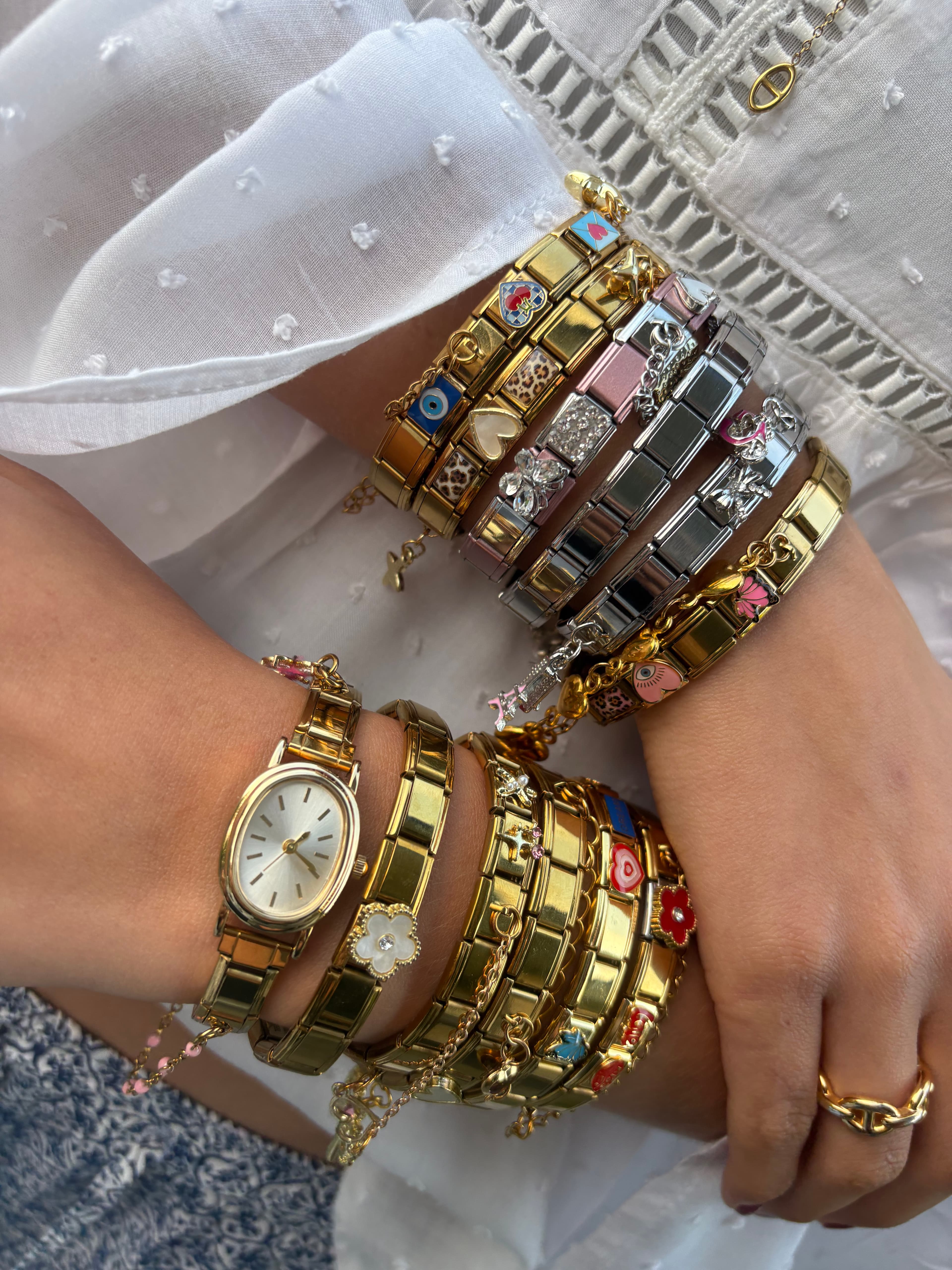 Gouden charm armbanden gedragen om de pols